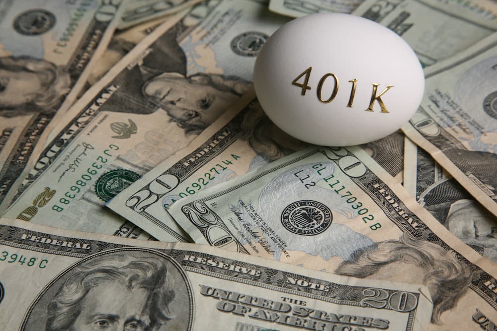 Egg with "401K" on top of twenty-dollar bills