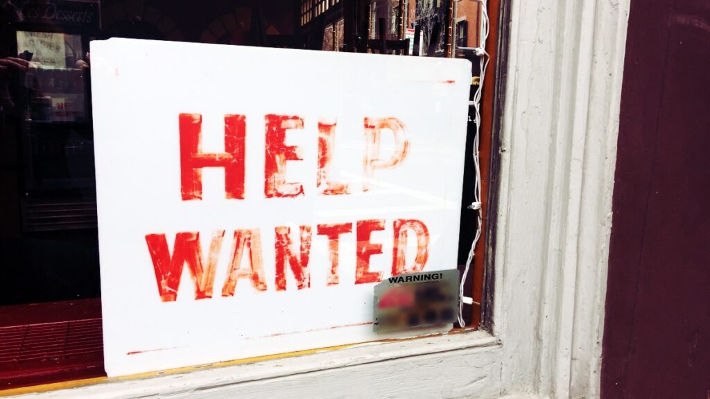 help wanted sign in window showing need for job search activity