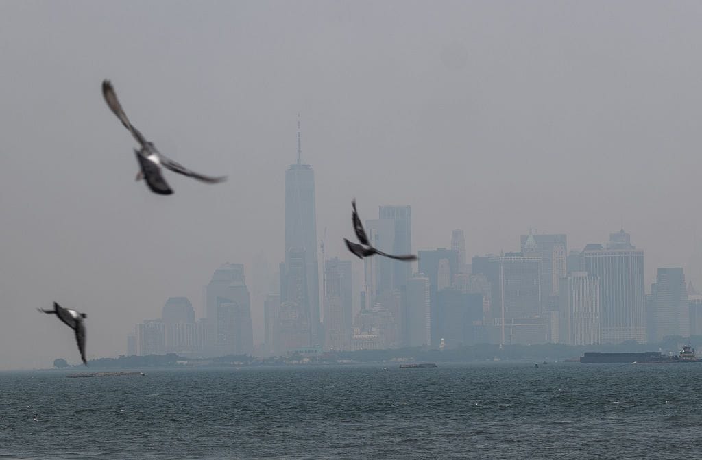 Haze from Canadian wildfires blankets the Manhattan skyline as seen from a Brooklyn pier on July 15, 2026 in New York City. 