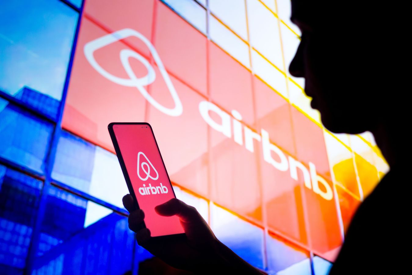 image of Airbnb on a phone and building